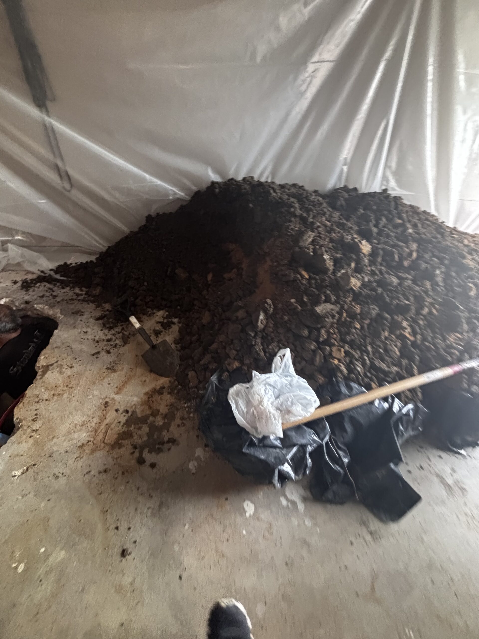 Pile of excavated soil from sewer line replacement under garage floor